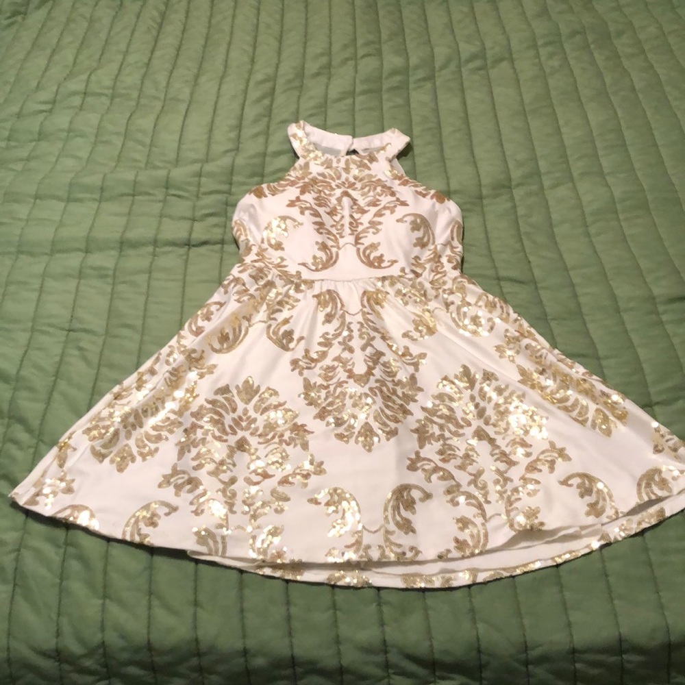 A pretty white dress with gold sequence designs.